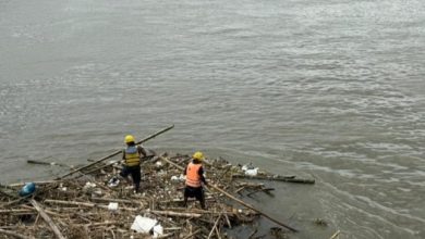 Photo of Puluhan Personel Turun Tangan, Potongan Kayu dan Bambu di Kaki Jembatan Lama Kediri Dibersihkan
